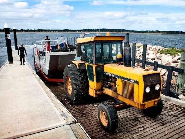 Picture of a tractor towing an oyster boat on a trailer.