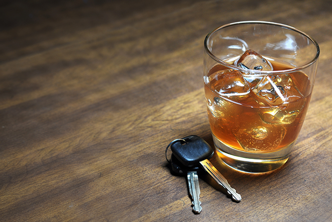 picture is of a glass of whiskey with a set of vehicle keys next to it