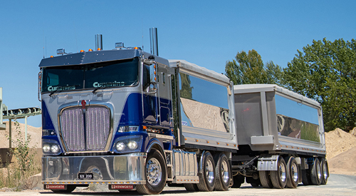 image is of a flat nosed 3-axle rigid truck towing a 4-axle dog trailer